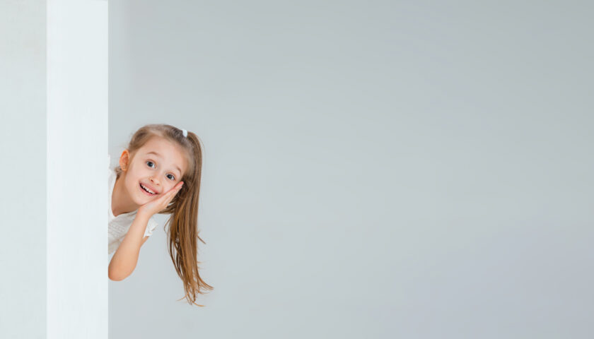 tête d'une petite fille qui dépasse d'un mur