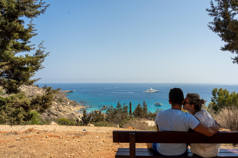 un couple sur un banc au bord de la mer