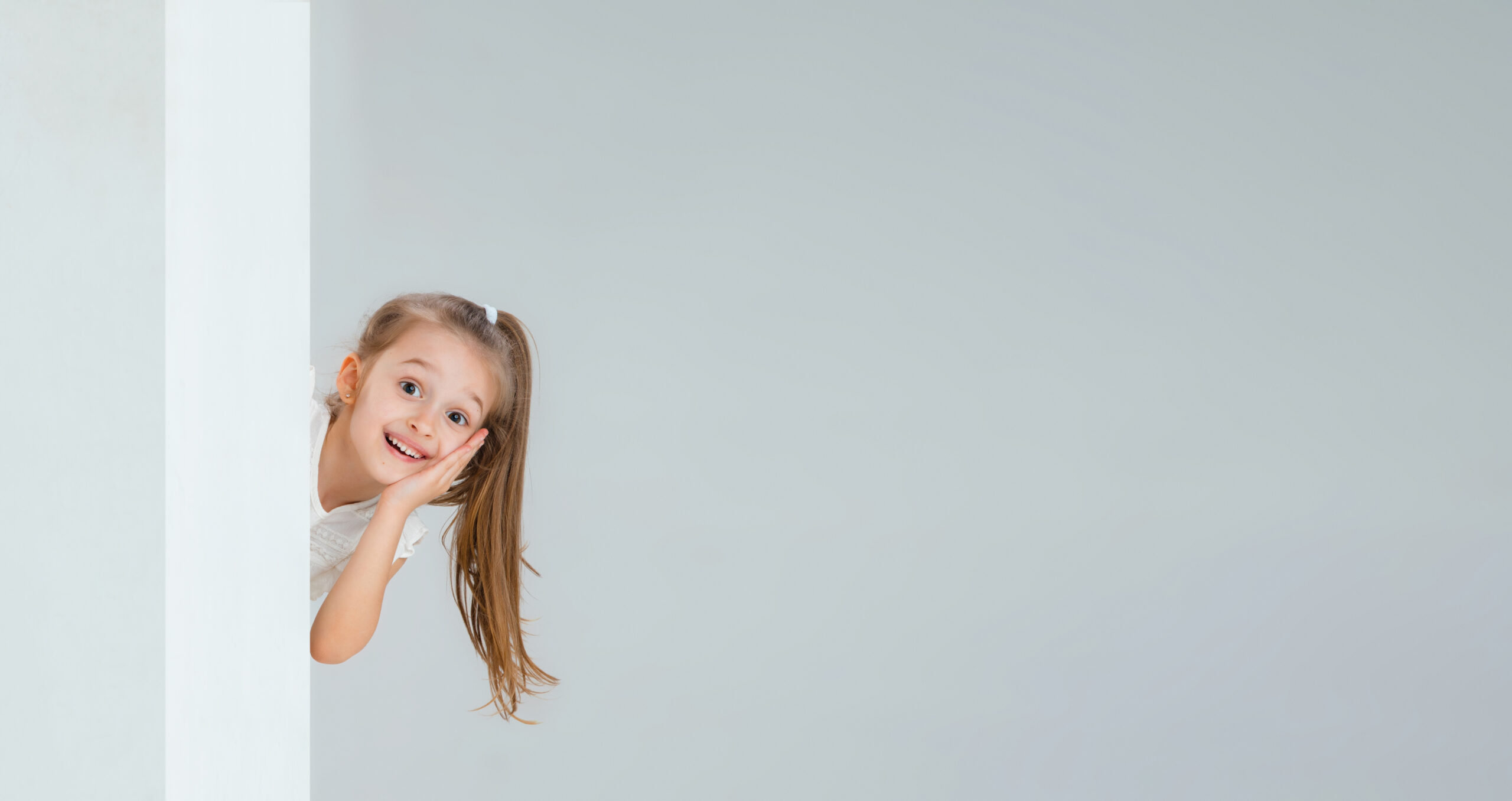 tête d'une petite fille qui dépasse d'un mur